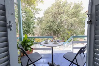 a patio with a table and chairs on a balcony at Rastoni - Beach Family House in Chorafakia