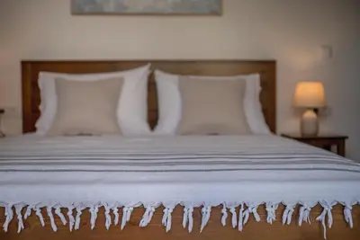 a bed with white sheets and pillows at Villa Terra Nuova in Kalyves
