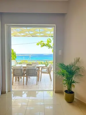 a dining room with a table and a view of the ocean at Vista Mare apartments in Palaiochóra
