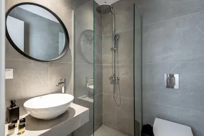 a bathroom with a sink and a glass shower at Amarillide rooms in Chania Town