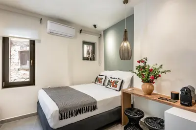 a bedroom with a bed and a table with flowers at Amarillide rooms in Chania Town
