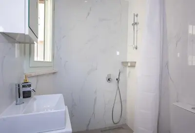 a white bathroom with a shower and a sink at Casa Elysium - Chania Old City in Chania Town