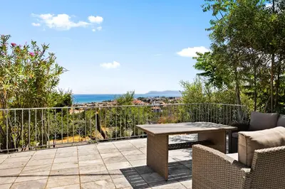 a patio with a table and chairs on a balcony at Delta Sea View House in Plataniás