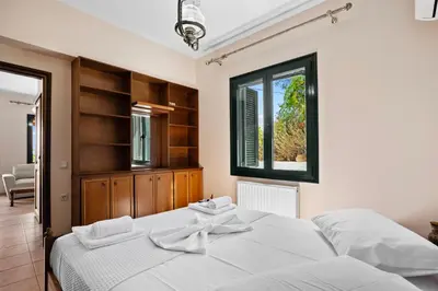 a bedroom with two white beds and a window at Delta Sea View House in Plataniás