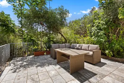 a patio with a couch and a wooden table at Delta Sea View House in Plataniás