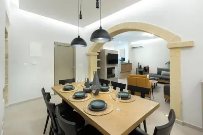 a dining room and living room with a table and chairs at Villa Savina in Plátanos