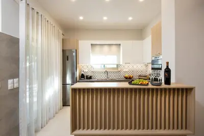 a kitchen with a counter with a sink and a refrigerator at Villa Savina in Plátanos