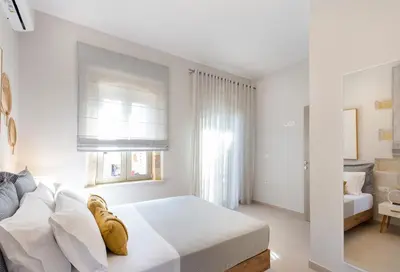 a white bedroom with a bed and a window at Villa Savina in Plátanos