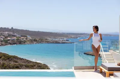 a woman in a white dress standing on the edge of a pool at Casablanca Villa in Chania Town
