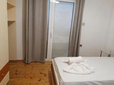 a bedroom with a bed with white sheets and a window at Charming Apartment In The Heart Of The City Chania in Chania Town