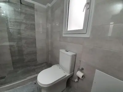 a bathroom with a toilet and a window and a shower at Charming Apartment In The Heart Of The City Chania in Chania Town