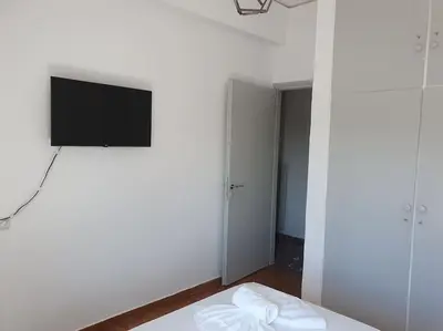 a white room with a flat screen tv on a wall at Charming Apartment In The Heart Of The City Chania in Chania Town