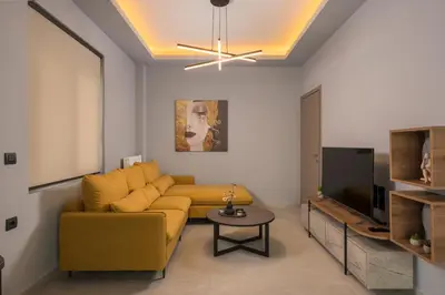a living room with a yellow couch and a tv at Casa Amarillo - Halepa in Chania Town