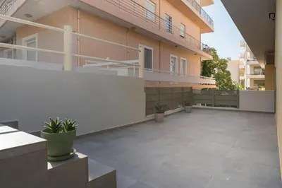 an empty courtyard of a building with potted plants at Casa Amarillo - Halepa in Chania Town