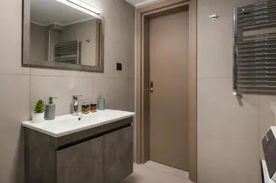 a bathroom with a sink and a mirror and a shower at Casa Amarillo - Halepa in Chania Town