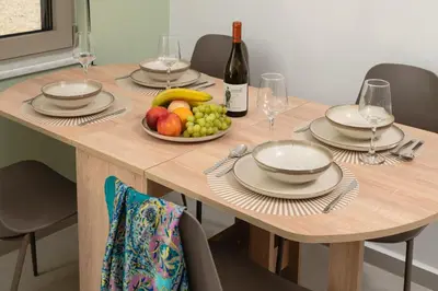 a wooden table with a bowl of fruit and a bottle of wine at Casa Makda in Parigoría