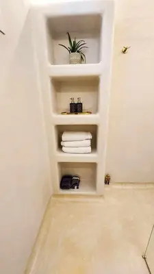 a bathroom with a shelf with towels and a plant at Seamoon in Plataniás