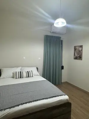 a bedroom with a bed and a blue curtain at Catherine Apartment in Chania Town