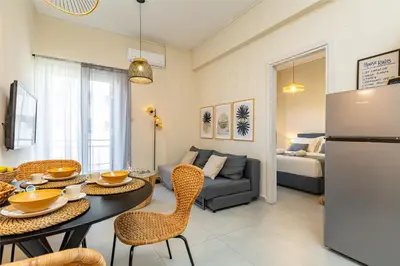 a kitchen and living room with a table and chairs at Jo's Central & Cozy Apartment in Chania Town