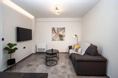 a living room with a couch and a tv at Celestial Apartments in Chania Town