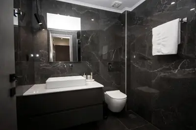 a bathroom with a sink and a toilet and a mirror at Celestial Apartments in Chania Town