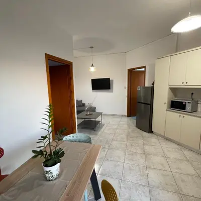 a living room with a table and a kitchen at Murele apartments in Daratso