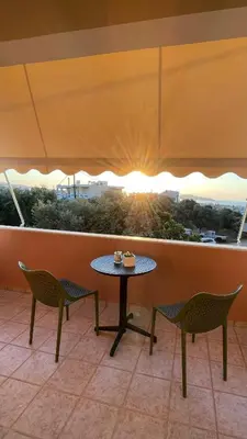 a table and chairs on a balcony with the sunset at Murele apartments in Daratso