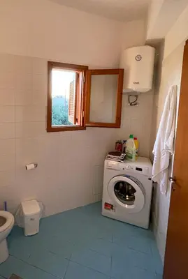 a bathroom with a washing machine and a toilet at Murele apartments in Daratso