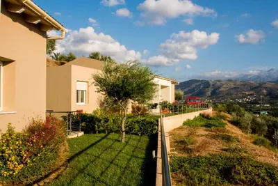 a view of a house with a green yard at Aksos Suites Accessible Accommodation in Ayiá