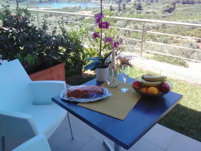 a blue table with a bowl of fruit on a balcony at Aksos Suites Accessible Accommodation in Ayiá