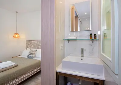 a bathroom with a sink and a bed at Casa Dione - Chania Old Town in Chania Town