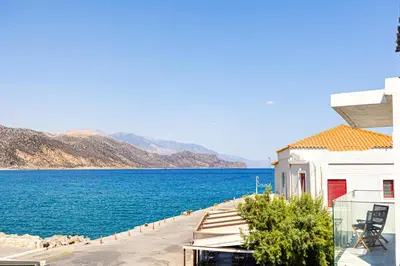a view of a large body of water next to a building at Aurora By Anasa in Palaiochóra