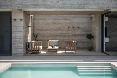 two chairs and a table next to a swimming pool at Alba Cave Villas in Chania Town