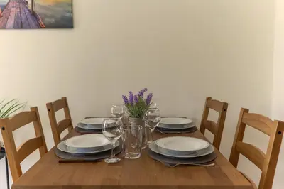 a wooden table with plates and wine glasses on it at Laurels Apartment in Chania Town