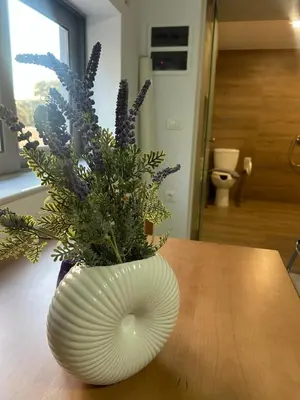 a white vase filled with purple flowers on a table at Nektar Beach Hotel in Stalos