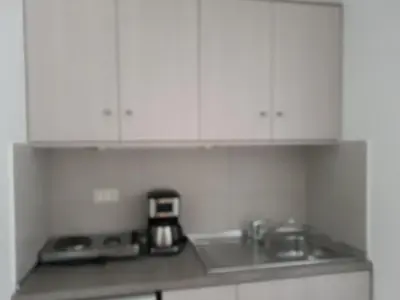 a kitchen counter with white cabinets and a sink at Nektar Beach Hotel in Stalos