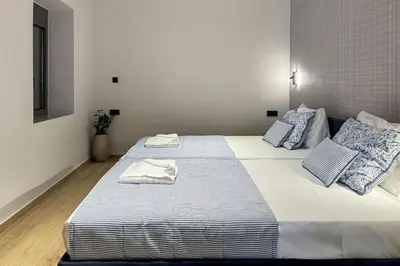 a bedroom with two beds with blue and white pillows at Casa in giardino in Chania Town