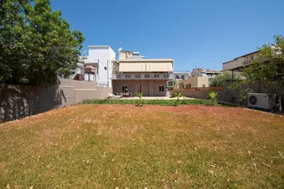 a view of a yard with a house at Cozy Rena luxury apartment with free private parking in Chania Town