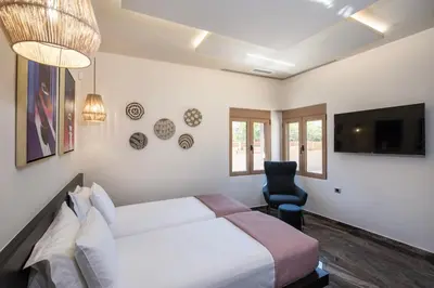 a bedroom with a bed and a chair and a tv at Cozy Rena luxury apartment with free private parking in Chania Town