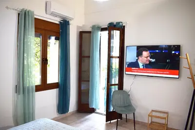 a bedroom with a television on a wall with a chair at NAOS-Sea front vacation rental by Chania center in Chania Town