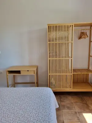 a bedroom with a bed and a wooden book shelf at All Season Lovely Seafront Cottage in Kissamos