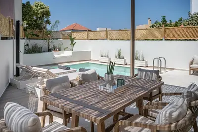 a patio with a table and chairs and a pool at Villa Seyian in Chania Town
