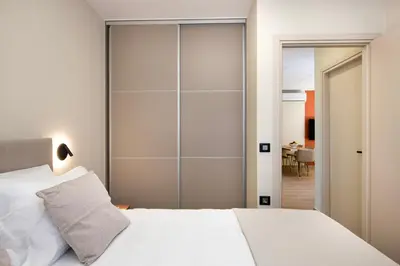 a bedroom with a white bed and a sliding glass door at Kalopsia Luxury Apartment Near Chania in Chania Town