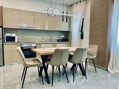 a kitchen with a wooden table and chairs at Stone Luxury Suite in Galatás