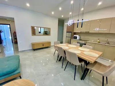 a kitchen and dining room with a table and chairs at Stone Luxury Suite in Galatás