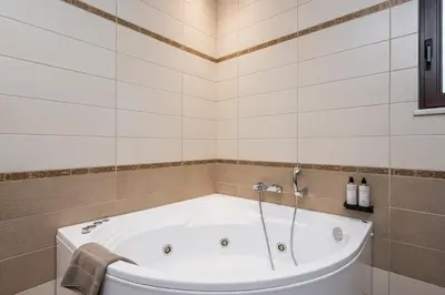 a bath tub in a tiled bathroom at Villa Wisdom - Elegant & Homely with Pool, Galatas in Chania Town