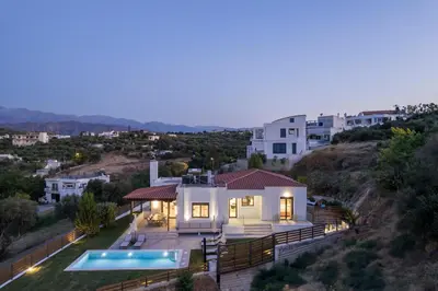 a villa with a swimming pool at night at Villa Wisdom - Elegant & Homely with Pool, Galatas in Chania Town