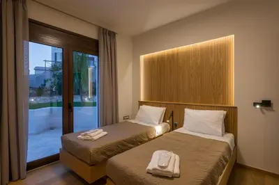 a hotel room with two beds and a window at Villa Wisdom - Elegant & Homely with Pool, Galatas in Chania Town