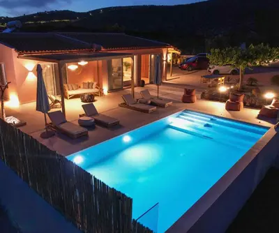 a swimming pool in a backyard at night at Yemaya Sea View Villa in Chania Town