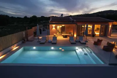 a swimming pool on a patio with a house at Yemaya Sea View Villa in Chania Town